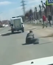 走行中の車から落下する男