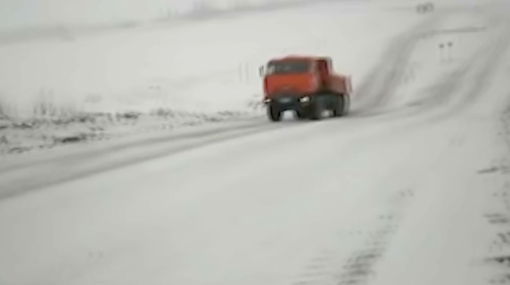 雪の坂道に苦労するトラック