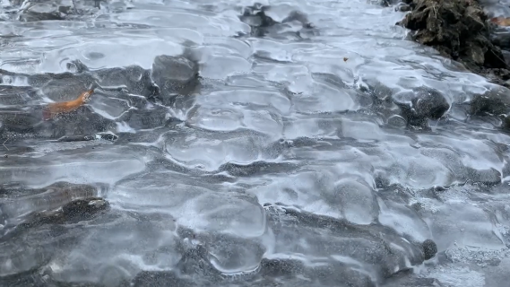 凍った滝の下を進む気泡