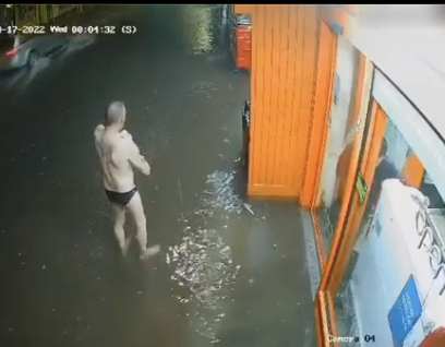 雨で身体を洗う男