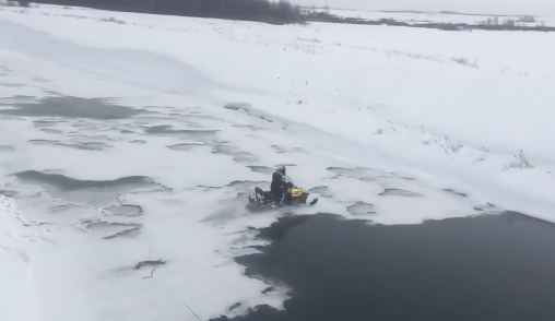 氷が割れて水没するスノーモービル