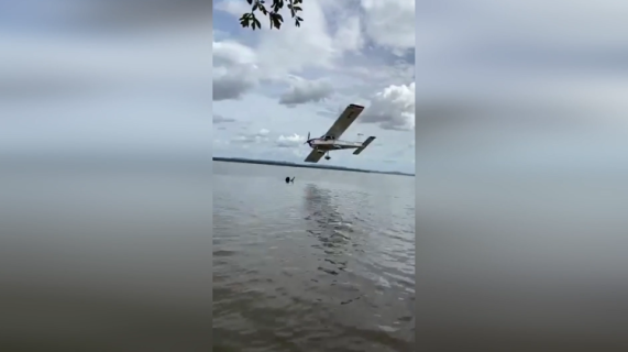 海水浴客の頭上スレスレを飛ぶ飛行機