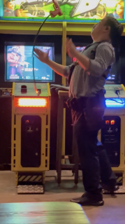 アーケードゲームで華麗な銃さばきを披露する男