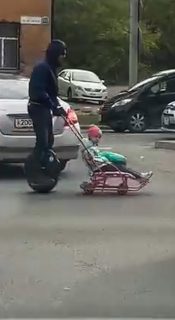 渋滞時に電動一輪車でベビーカーを押すお父さん