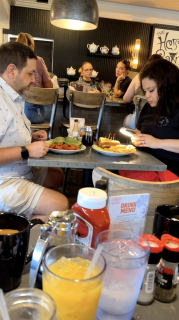 女性が食べ物の写真を撮り終えるまで待つ男性