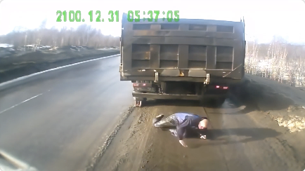 後退するトラックからギリギリ逃げる男性