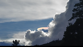 太陽光に照らされた虹色のレンズ雲