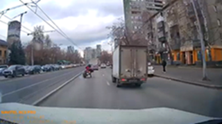 スリップしたライダーが車に衝突