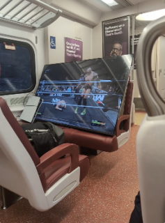 電車内に大型テレビを持ち込んでゲームをする男性