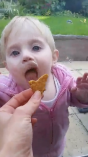 ガラス越しに食べようとする赤ちゃん