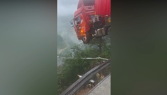 崩落した橋から宙吊り状態になったトラック運転手