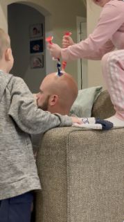 父のハゲ頭で遊ぶ子どもたち