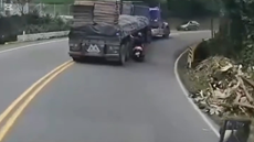 バイクが転倒しトラックに轢かれかける運転手