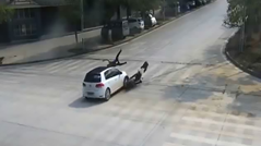 車と衝突したライダーが車の屋根の上に座り込む